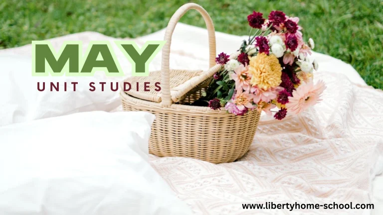 Wicker basket with colorful spring flowers on a picnic blanket for May homeschool unit studies.