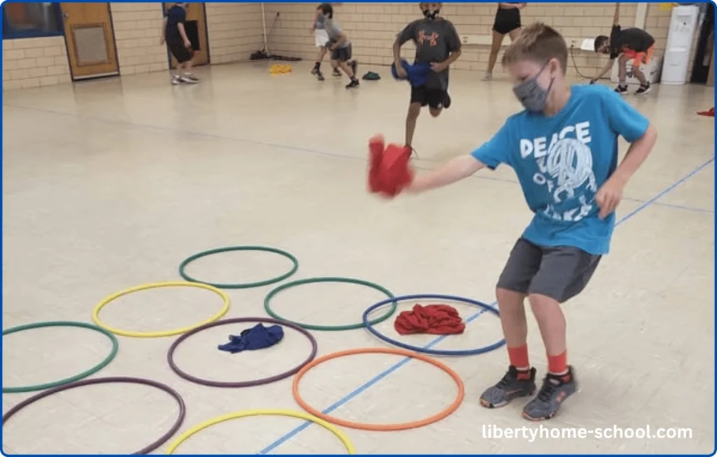 15 PE Games for 10-Year-Olds at Home 12 Children tossing beanbags into hula hoops arranged in a tic-tac-toe grid on the floor