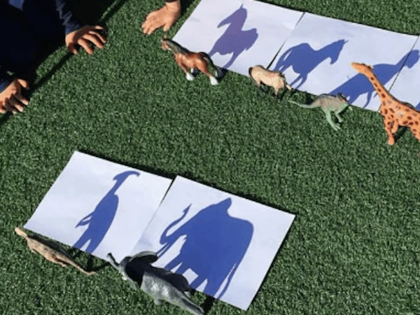 10 Summer Activities for Kids 12 Kids drawing outlines of toys and hands using shadows in bright sunlight