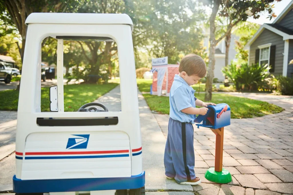 Illustration of a red mailbox and a friendly mail truck with envelopes, celebrating National Postal Worker Day.